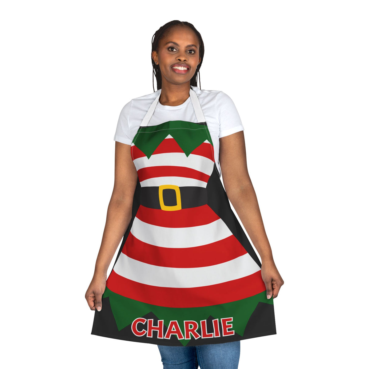 A woman modeling a Christmas elf-themed apron with red and white stripes, green accents, a black belt graphic with a gold buckle, and the name 'CHARLIE' printed at the bottom.