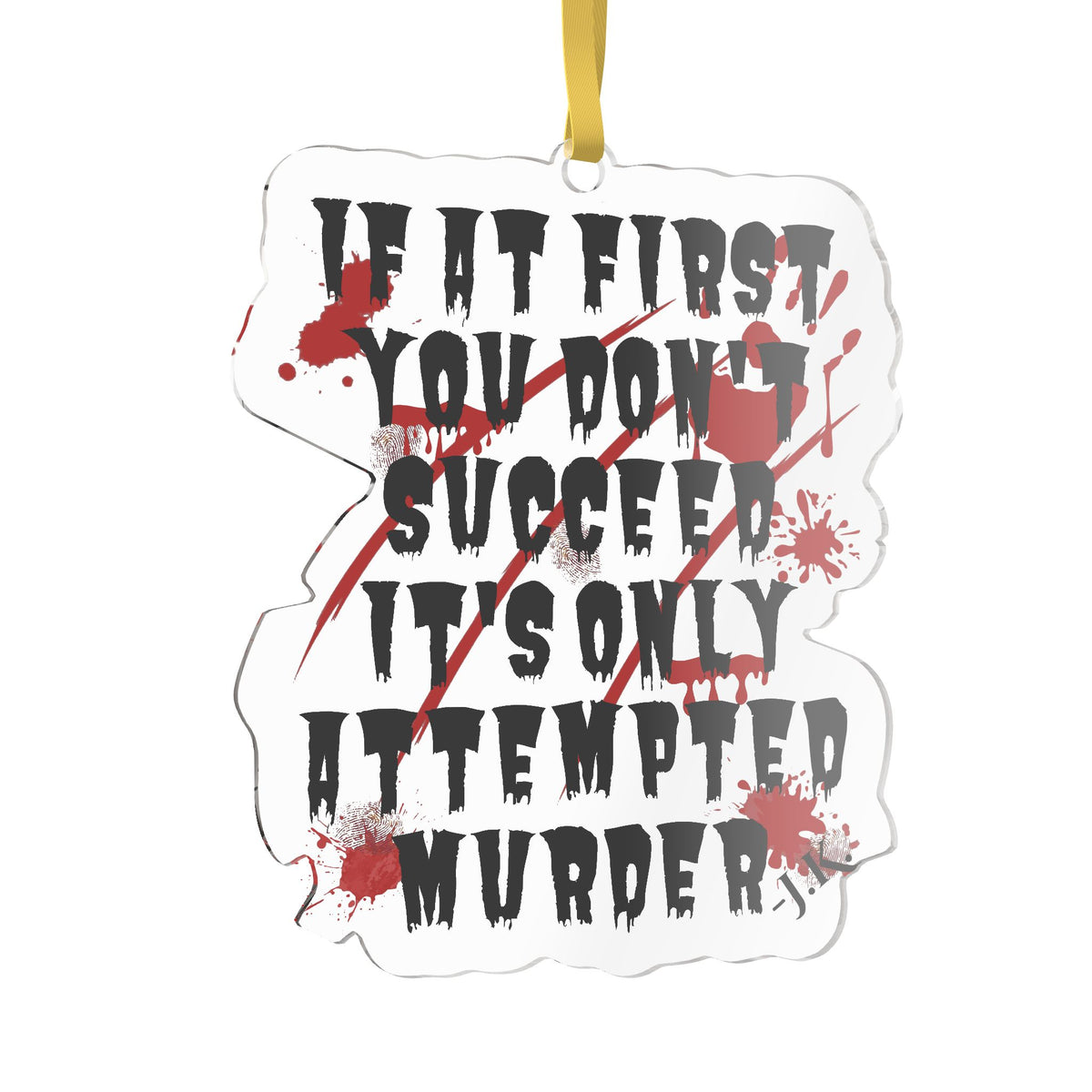 A die-cut white ornament featuring the horror-themed quote 'IF IT FIRST YOU DON'T SUCCEED IT'S ONLY ATTEMPTED MURDER' in black distressed lettering, crossed out by red diagonal lines and red blood splatters, with a gold hanging ribbon at the top.