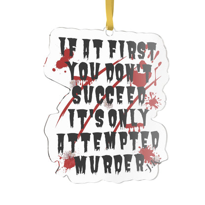 A die-cut white ornament featuring the horror-themed quote 'IF IT FIRST YOU DON'T SUCCEED IT'S ONLY ATTEMPTED MURDER' in black distressed lettering, crossed out by red diagonal lines and red blood splatters, with a gold hanging ribbon at the top.