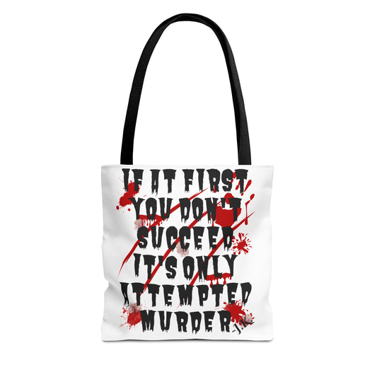 A white canvas tote bag with black handles, featuring a horror-themed graphic print in black and red text that reads 'IF IT FIRST YOU DON'T SUCCEED IT'S ONLY ATTEMPTED MURDER' with red blood splatter details, shown on a plain white background.