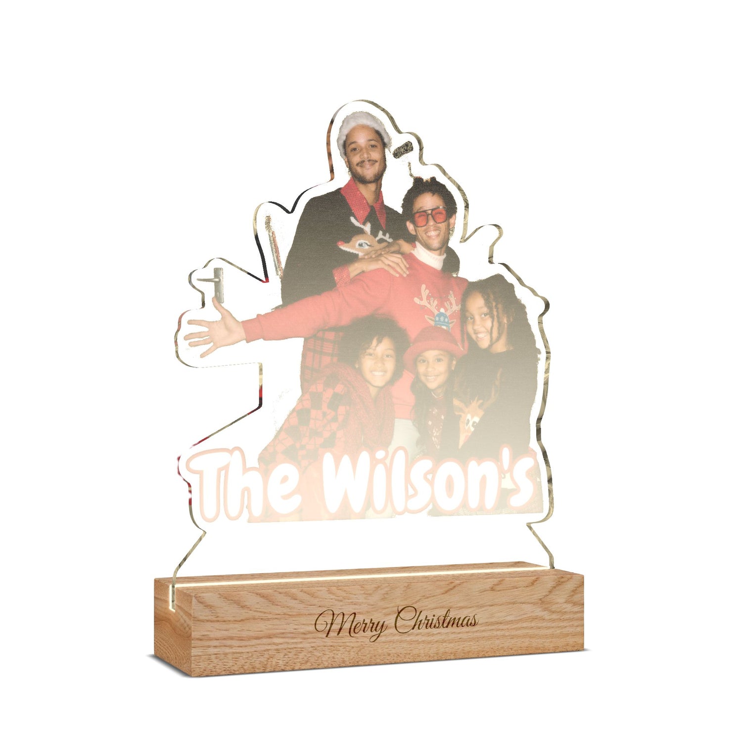 Personalized acrylic LED light sign shaped like a family portrait, featuring a photo of a man and children with the text 'The Wilson's' and a wooden base engraved with 'Merry Christmas'.
