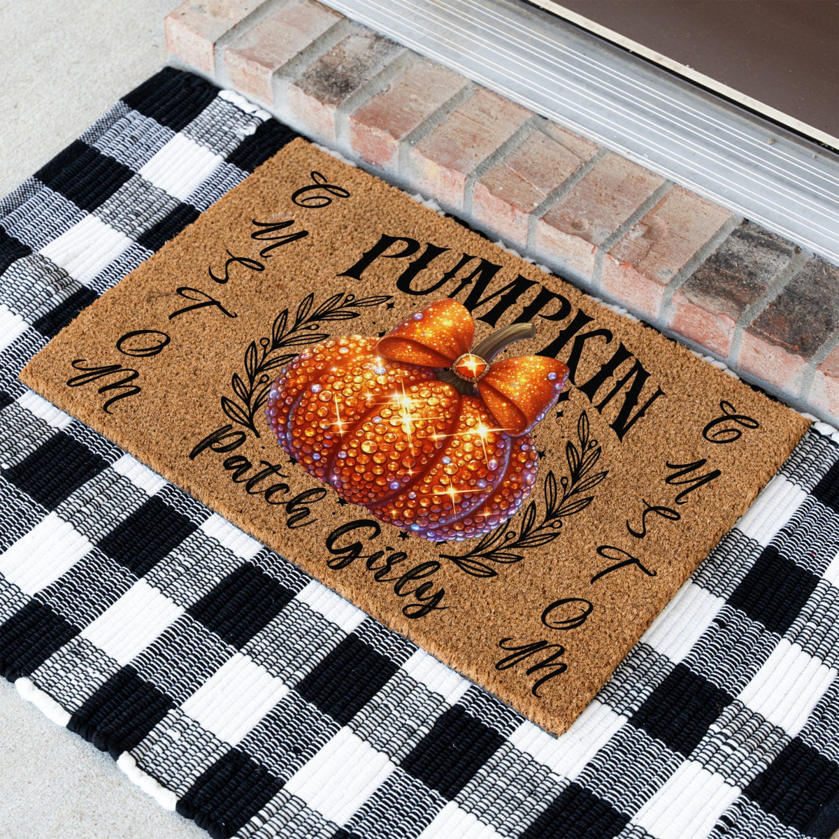 A rectangular brown coir doormat with a personalized pumpkin design and the text 'Pumpkin Patch Girly' and 'custom', placed on a black and white buffalo check blanket in front of a brick threshold.
