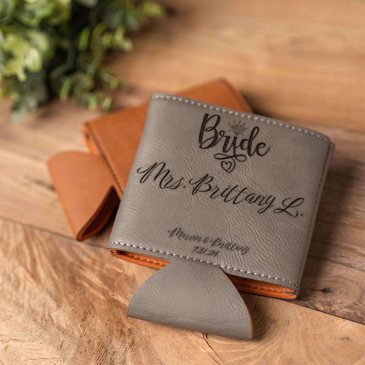 A personalized gray leather can cooler with black script text reading 'Bride Mrs. Brittany L.