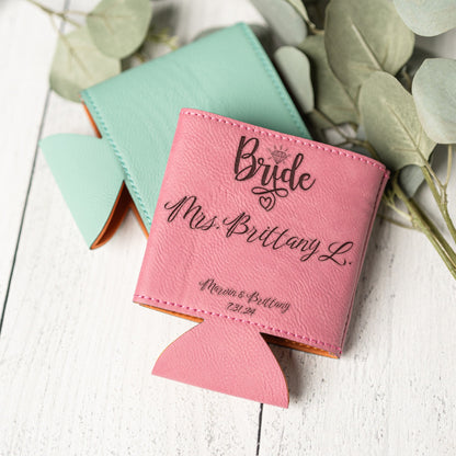 A pink leather can cooler bottle holder with custom black script engraving reading 'Bride Mrs. Brittany L.