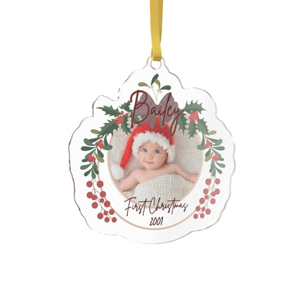 A personalized acrylic Christmas ornament with a scalloped edge, featuring a photo of a baby in a Santa hat surrounded by holly leaves and red berries. The custom name 'Bailey' is written at the top in cursive, and custom text 'First Christmas 2001' is written at the bottom.