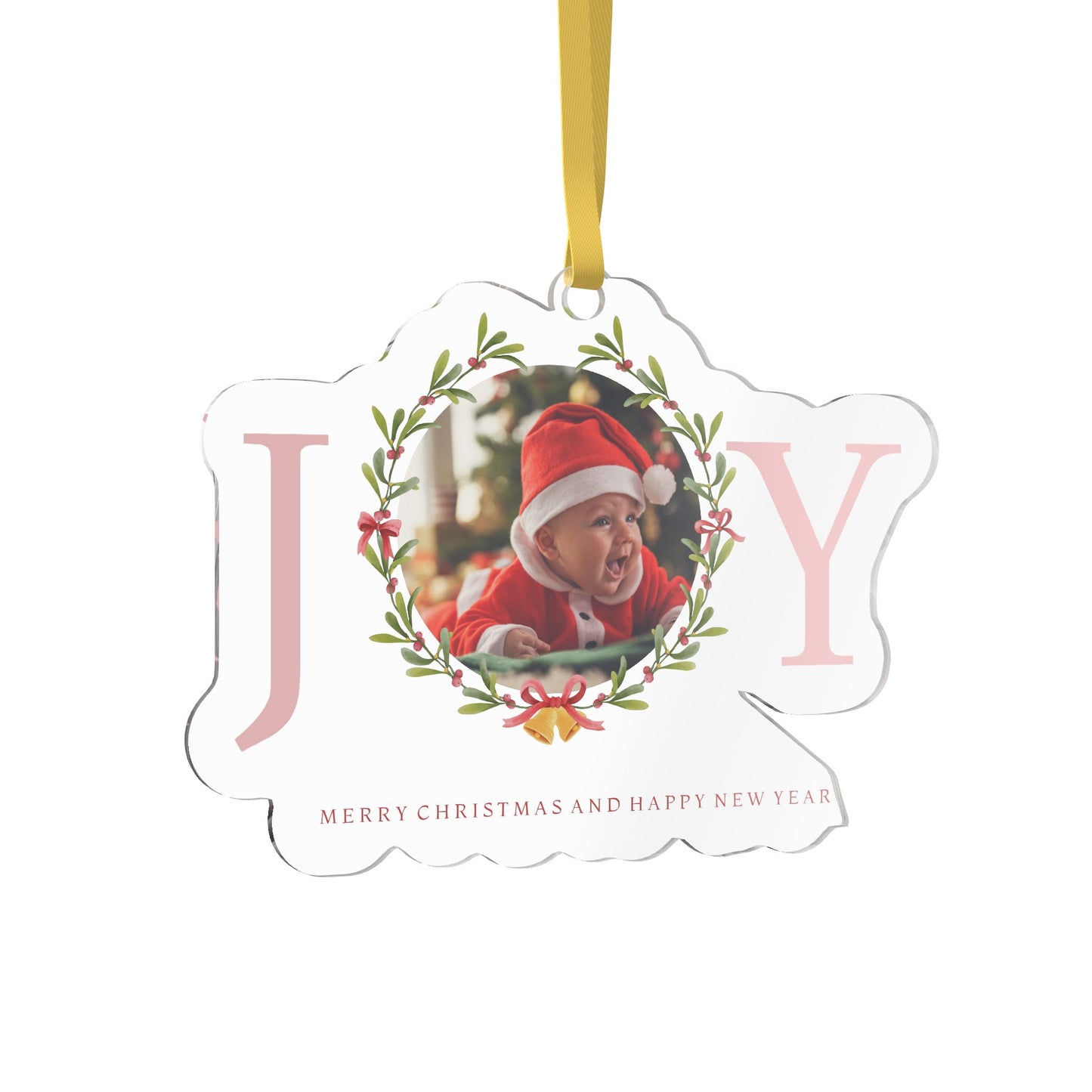A clear acrylic holiday ornament shaped like the word 'JOY' with a customizable photo of a baby in a Santa hat in the center, hanging from a yellow ribbon on a white background.