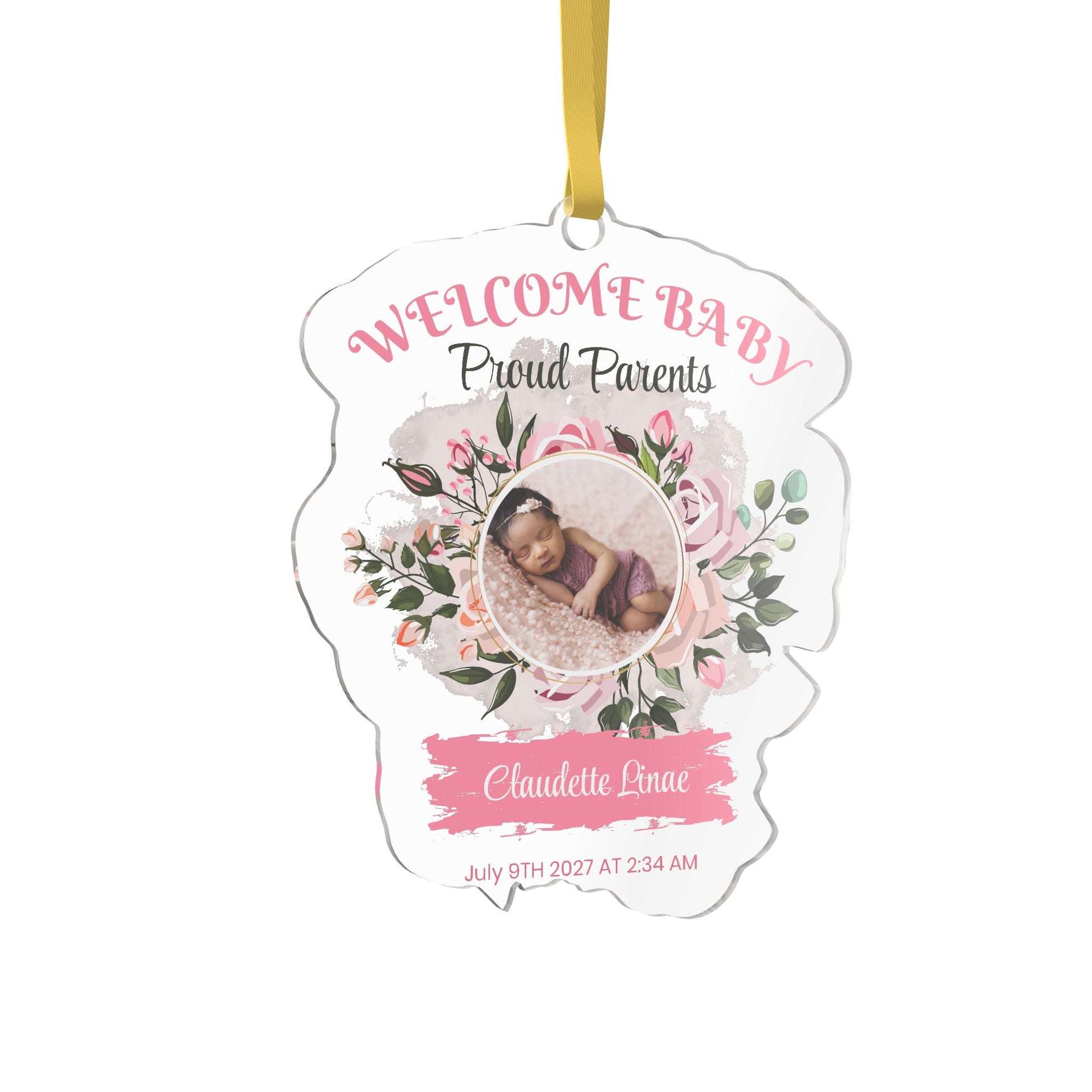 A custom welcome baby ornament shaped  die-cut, featuring a photo of a baby, pink floral illustrations, and the text 'WELCOME BABY Proud Parents' and 'Claudette Linae' on a white background with a gold hanging ribbon.