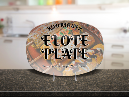 Decorative platter with 'Rodriguez Elote Plate and family members names' text on a kitchen counter.