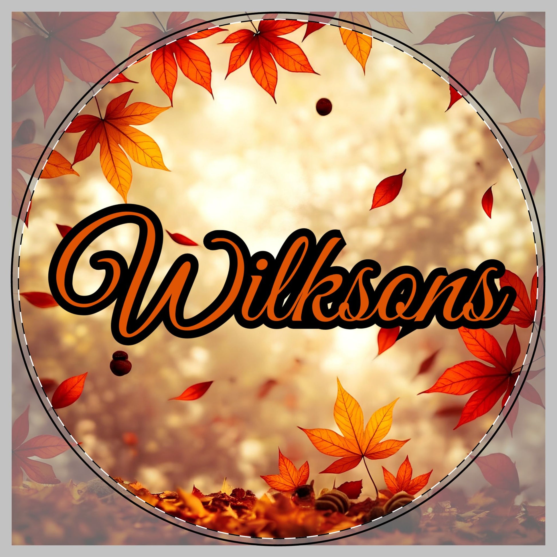 A circular autumn-themed graphic with the word 'Wilksons' in large orange script with a black outline, surrounded by red and orange maple leaves on a warm glowing beige background for a cutting board.