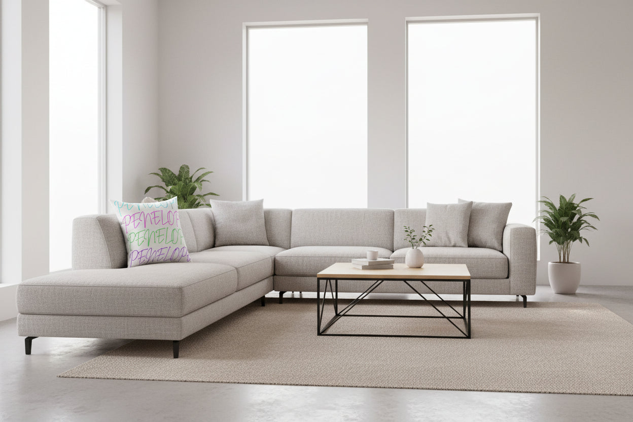 Pillow with 'PENELOPE' in colorful letters with a white background on a couch