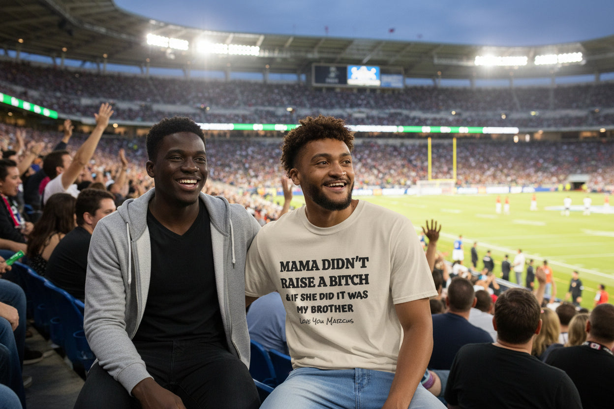 Man wearing a beige t-shirt with text that says mama didn't raise a bitch & if she did it was my brother, love you marcus, sitting on bleachers at a football game with his brother